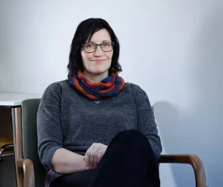 Colleen sitting in a chair smiling at the camera.